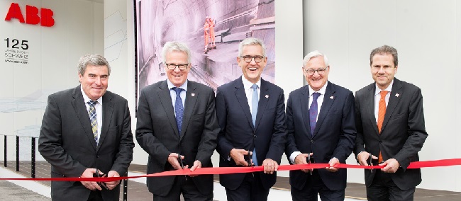 Five suited men are cutting a ribbon at ABB headquarters Australia.