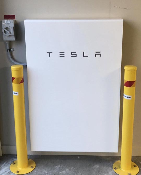 Tesla Powerwall in a garage with bollards
