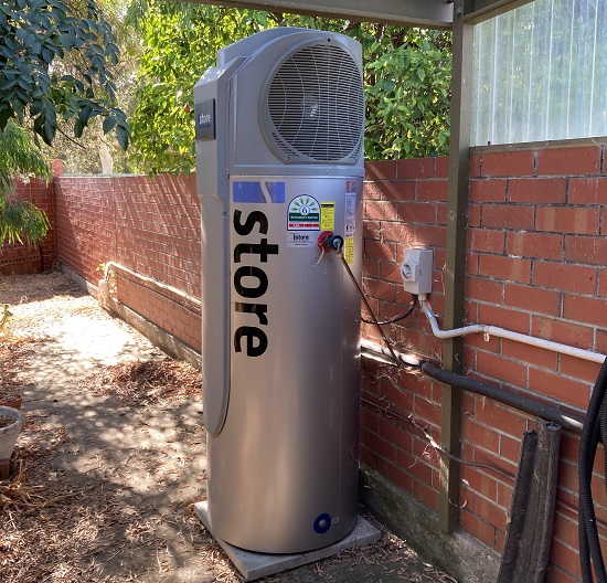 An istore heat pump hot water system with some spider webs.