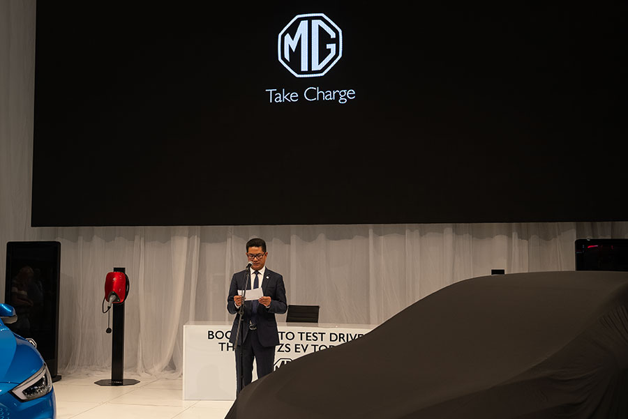 Leo of MG Motor speaking in front of veiled MG4 at Fully Charged Live Australia