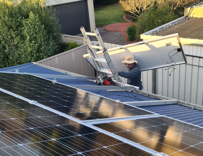 Climbing a ladder with a solar panel
