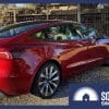 A refreshed Tesla Model 3 next to a Challenger tank.
