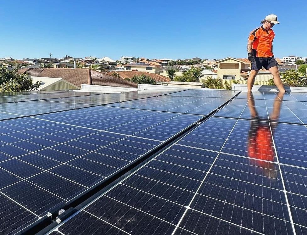 A man walks past some solar panels.