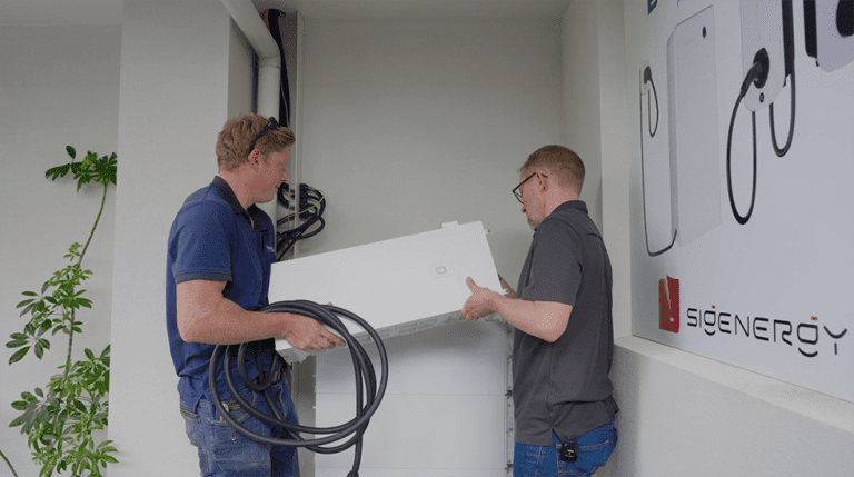 Two guys adding a DC charging module to the Sigenergy battery stack.
