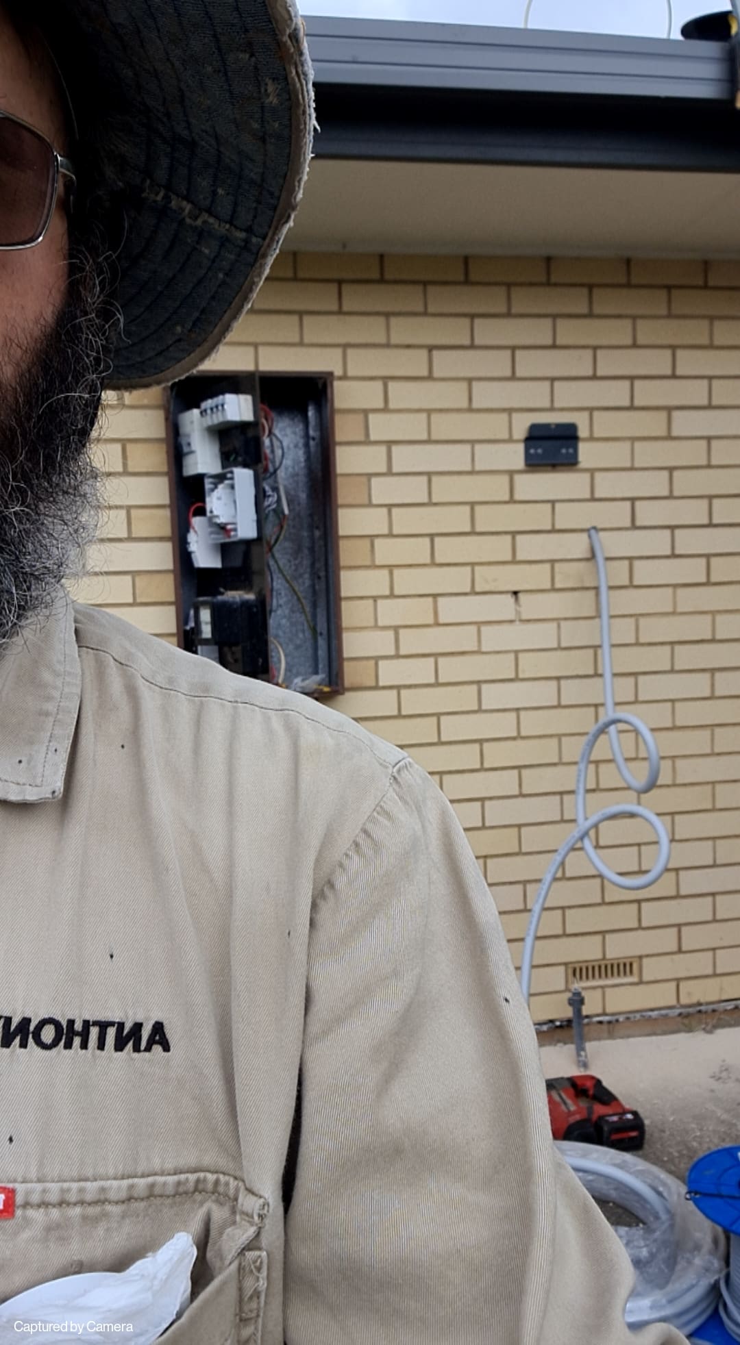 A photo of a man standing in front of electrical gear