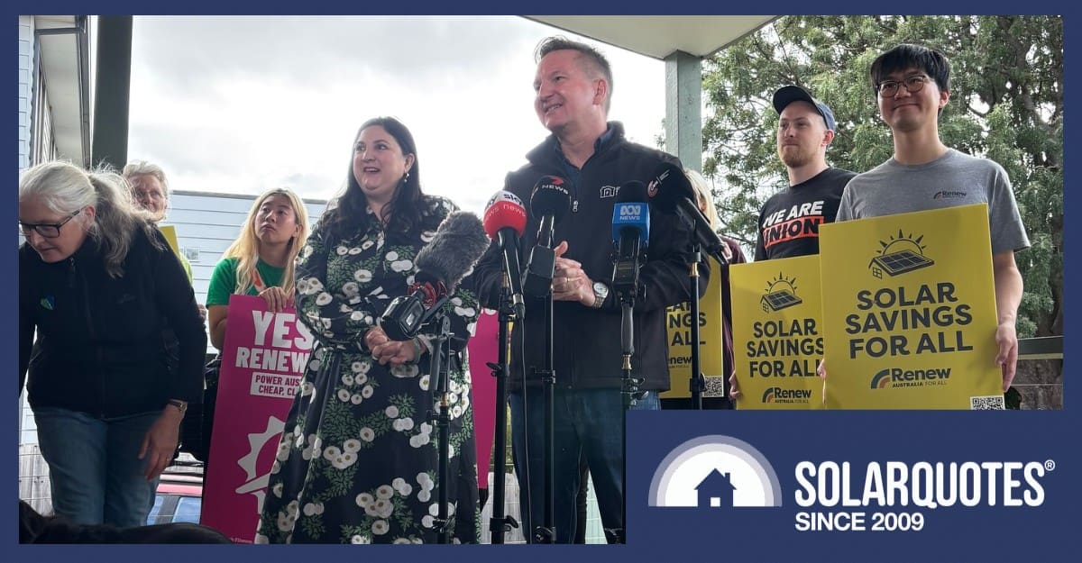 Chris Bowen campaigns during the election in front of signs promoting solar