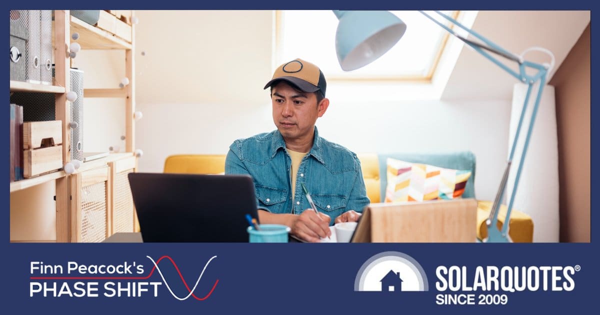 A man working from home with a sofa behind him
