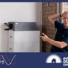 SolarQuotes founder finn Peacock clutches his head and points at a home battery system