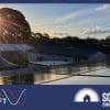 A sun sets over a premium brand of solar panels