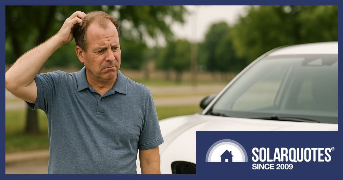 A puzzled man standing next to an EV