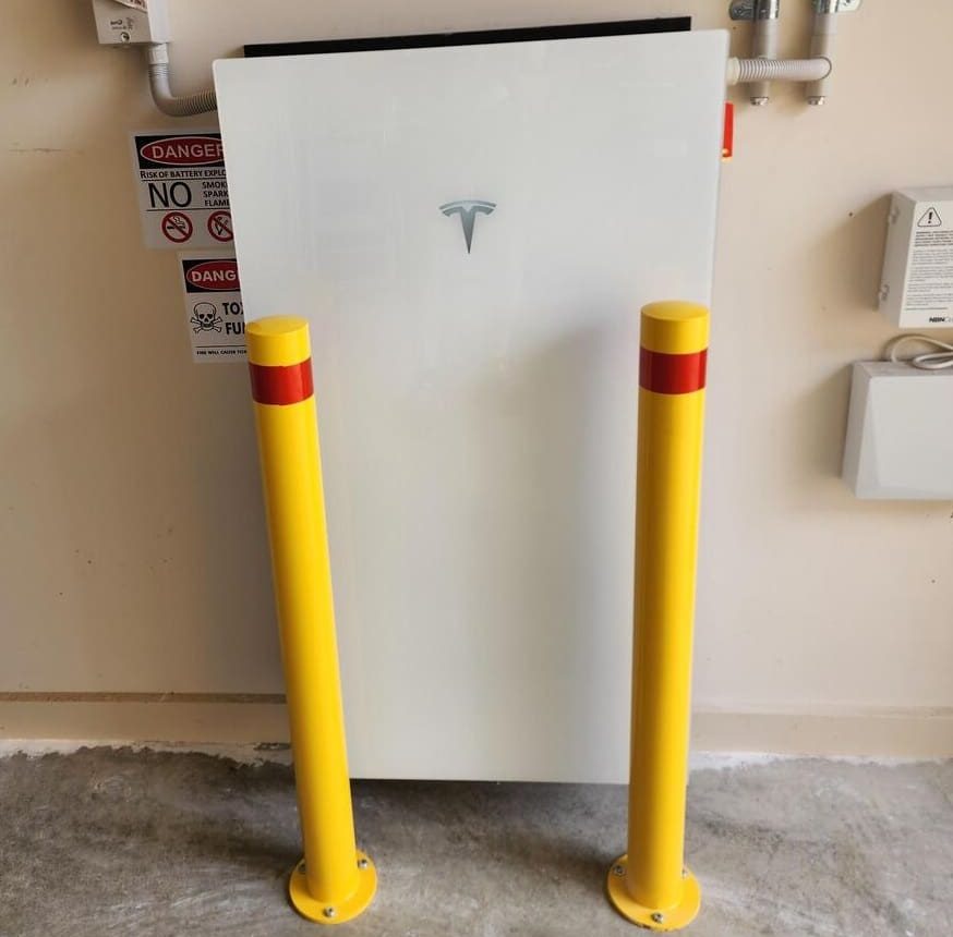 A Tesla battery guarded by bollards
