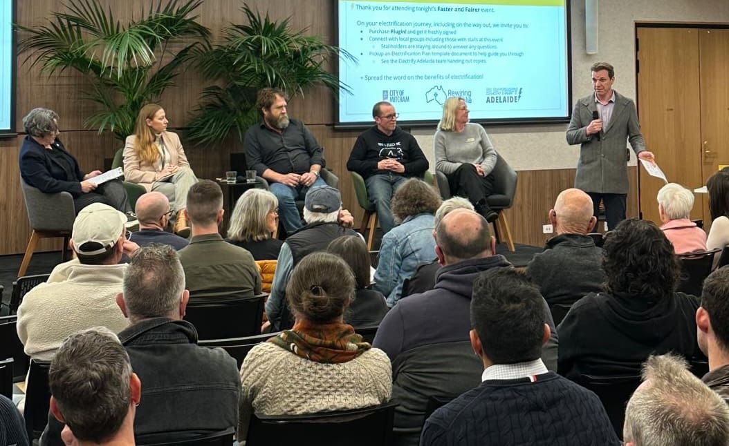 A panel of speakers before an audience.