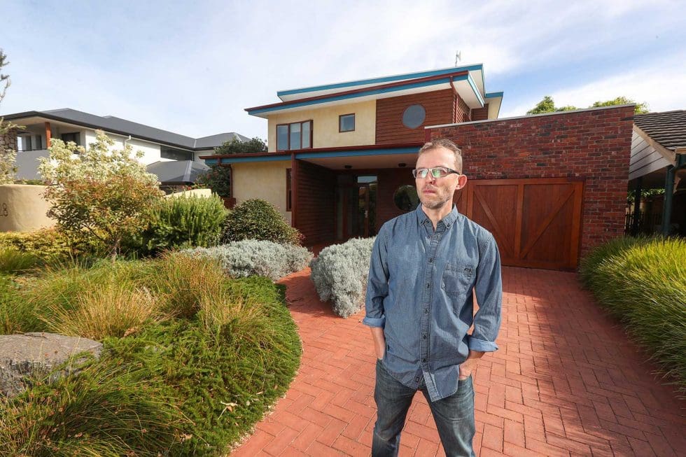A man standing in front of an energy efficient home