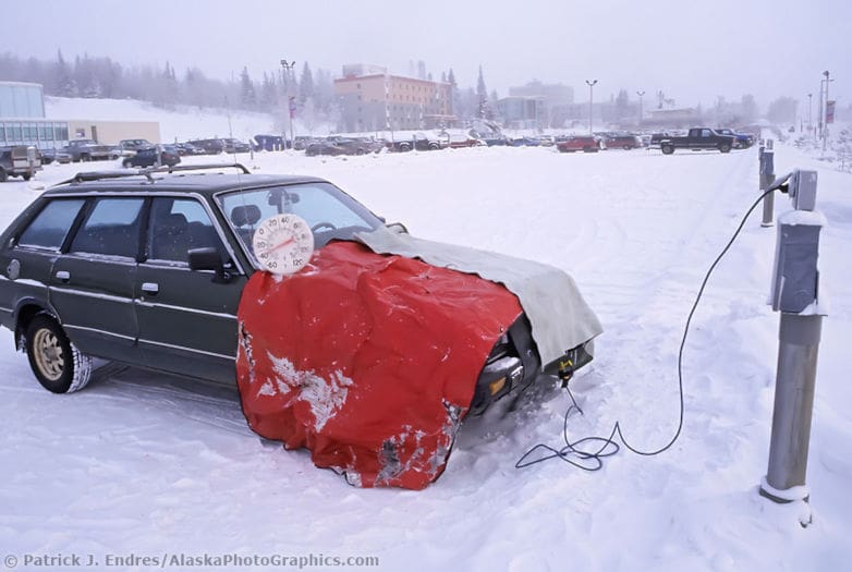 car parked in the snow connected to power outlet