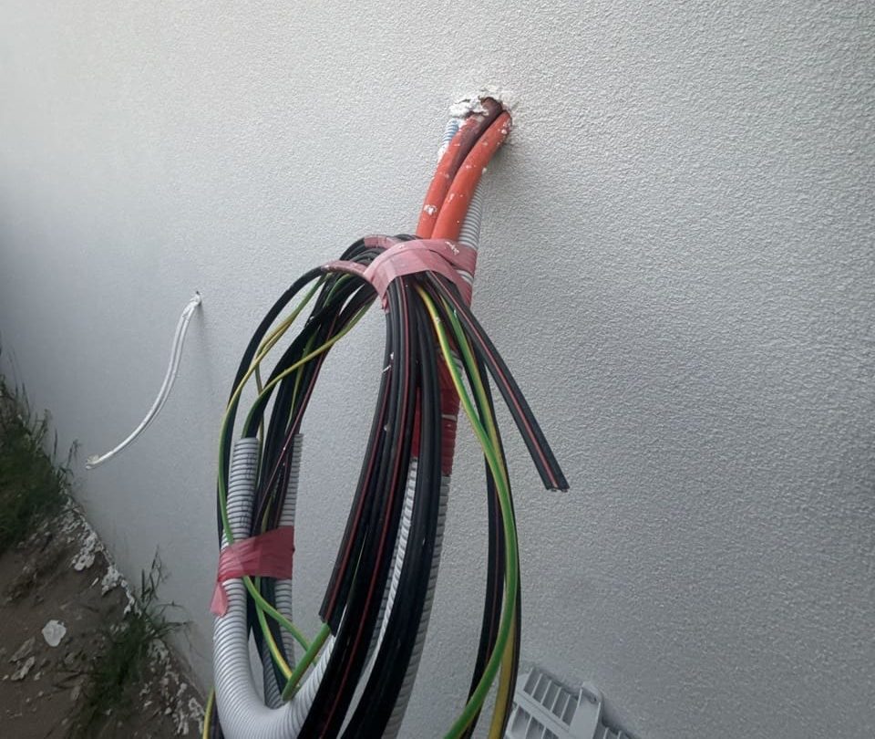Wires emerging from a freshly plastered wall