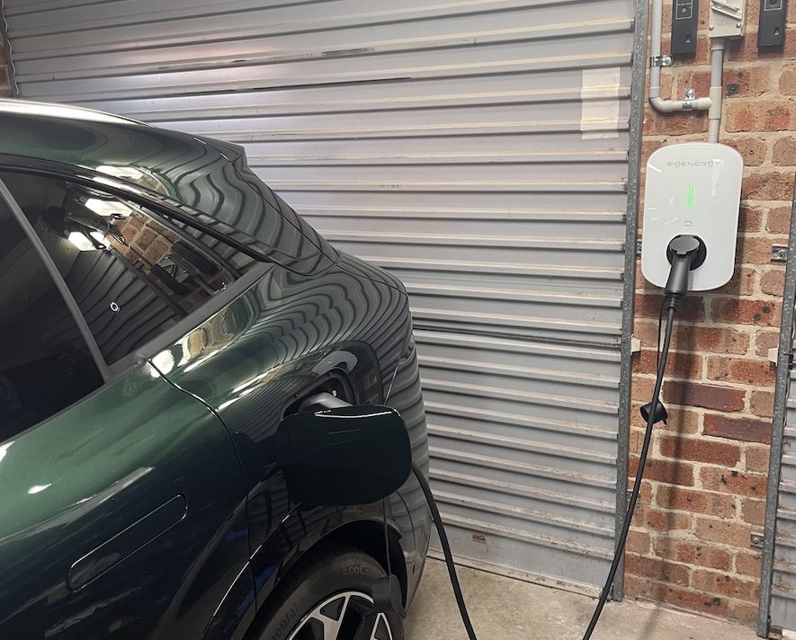 Green car charging in a garage.