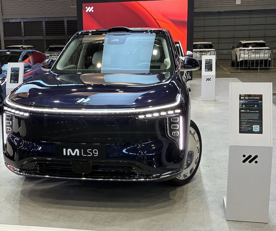 Dark blue EV SUV on a stage.