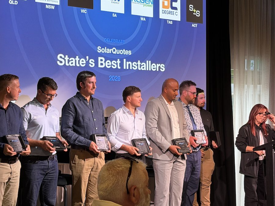 Men and one woman on stage holding awards with a banner behind them that reads SolarQuotes State's Best Installers 2026