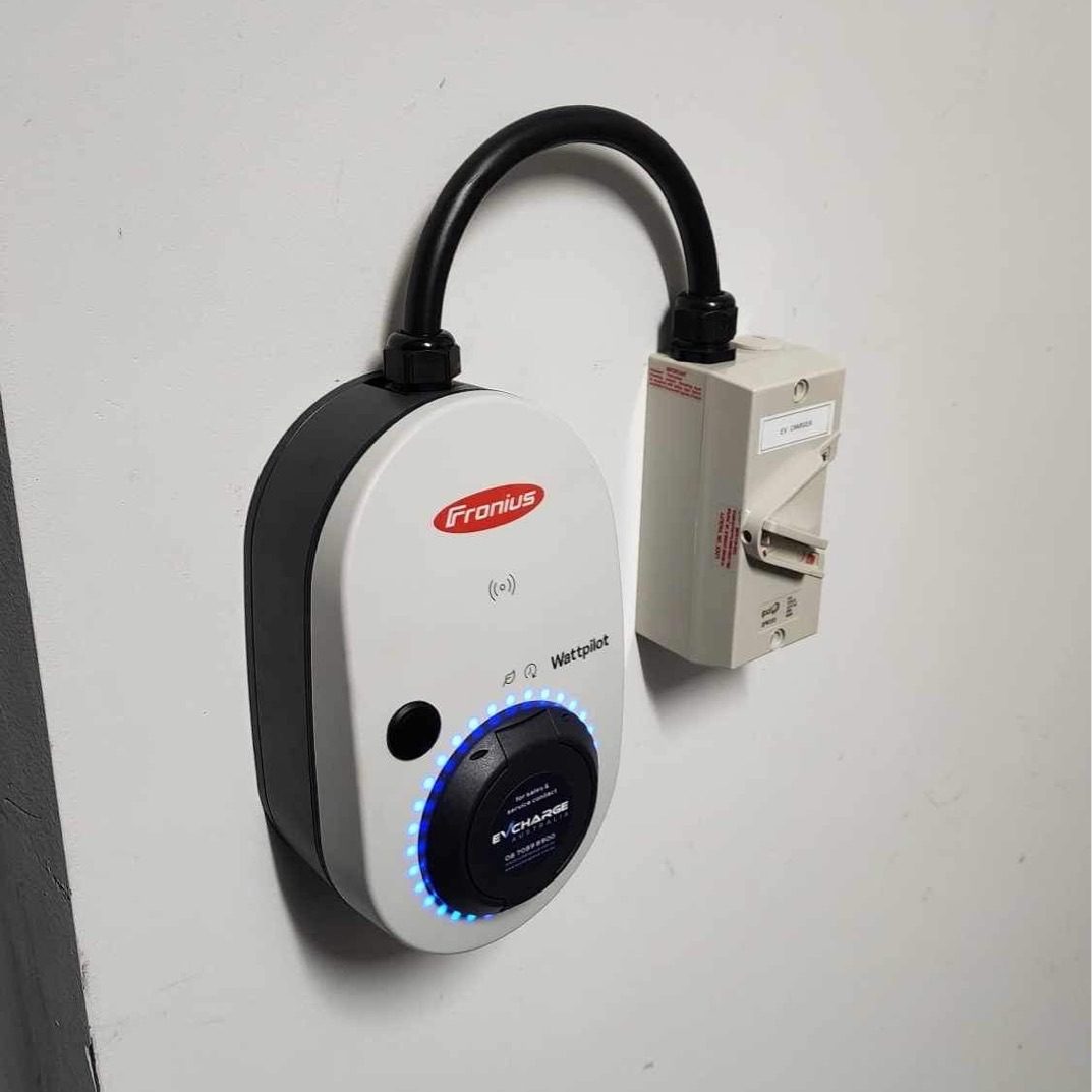 Fronius Wattpilot installed on a white garage wall.