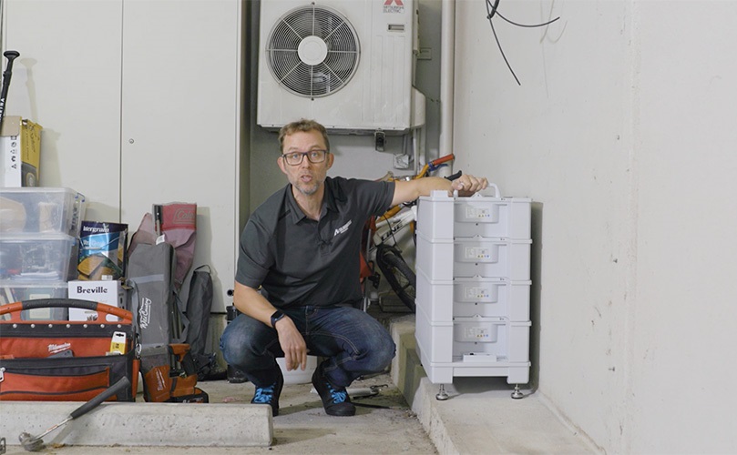 Finn next to a Sungrow home battery.