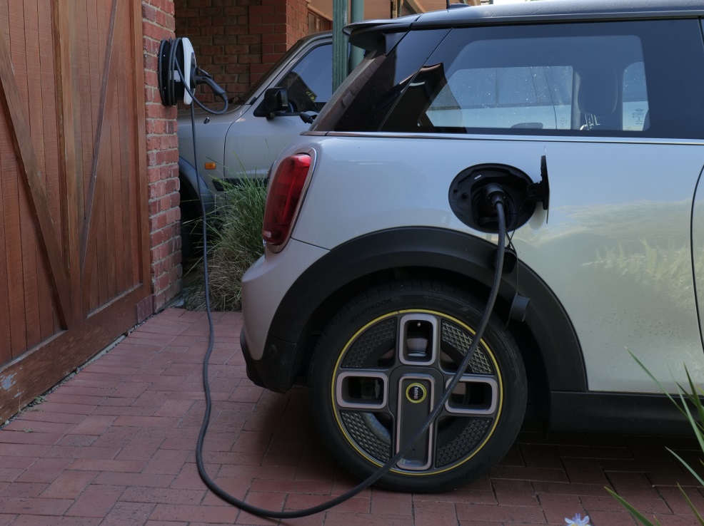 A home EV charger charging a car in a driveway