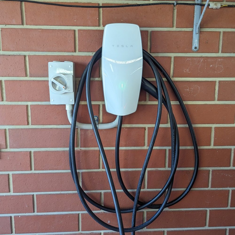 A Tesla Wall Connector installed on a garage wall,