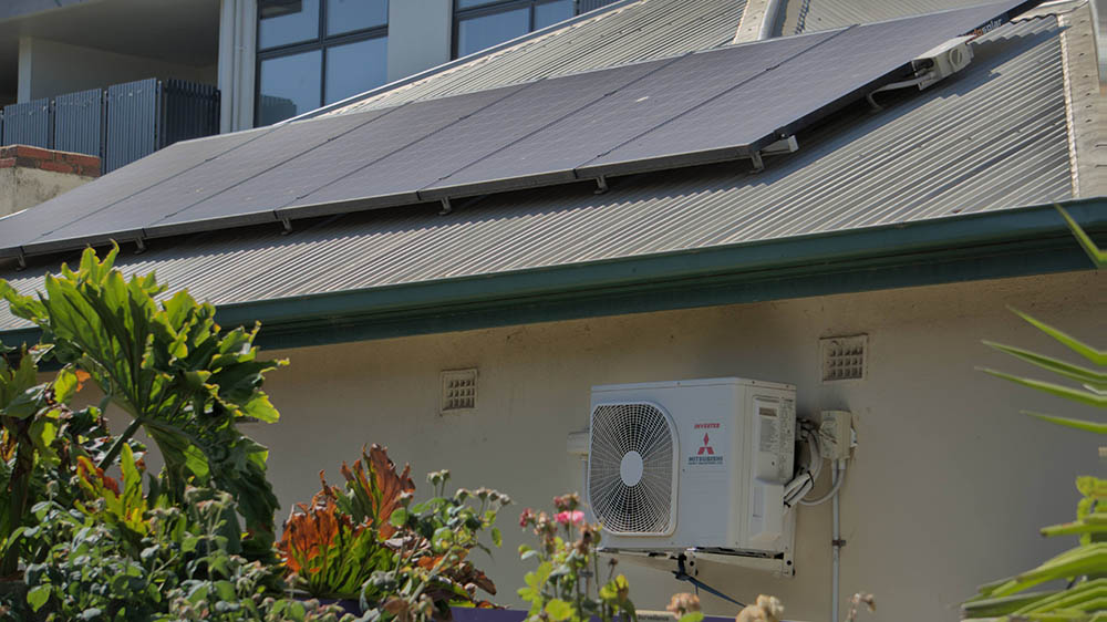 A Mitsubishi Heavy Industries air conditioner installed on the side of a house with solar.